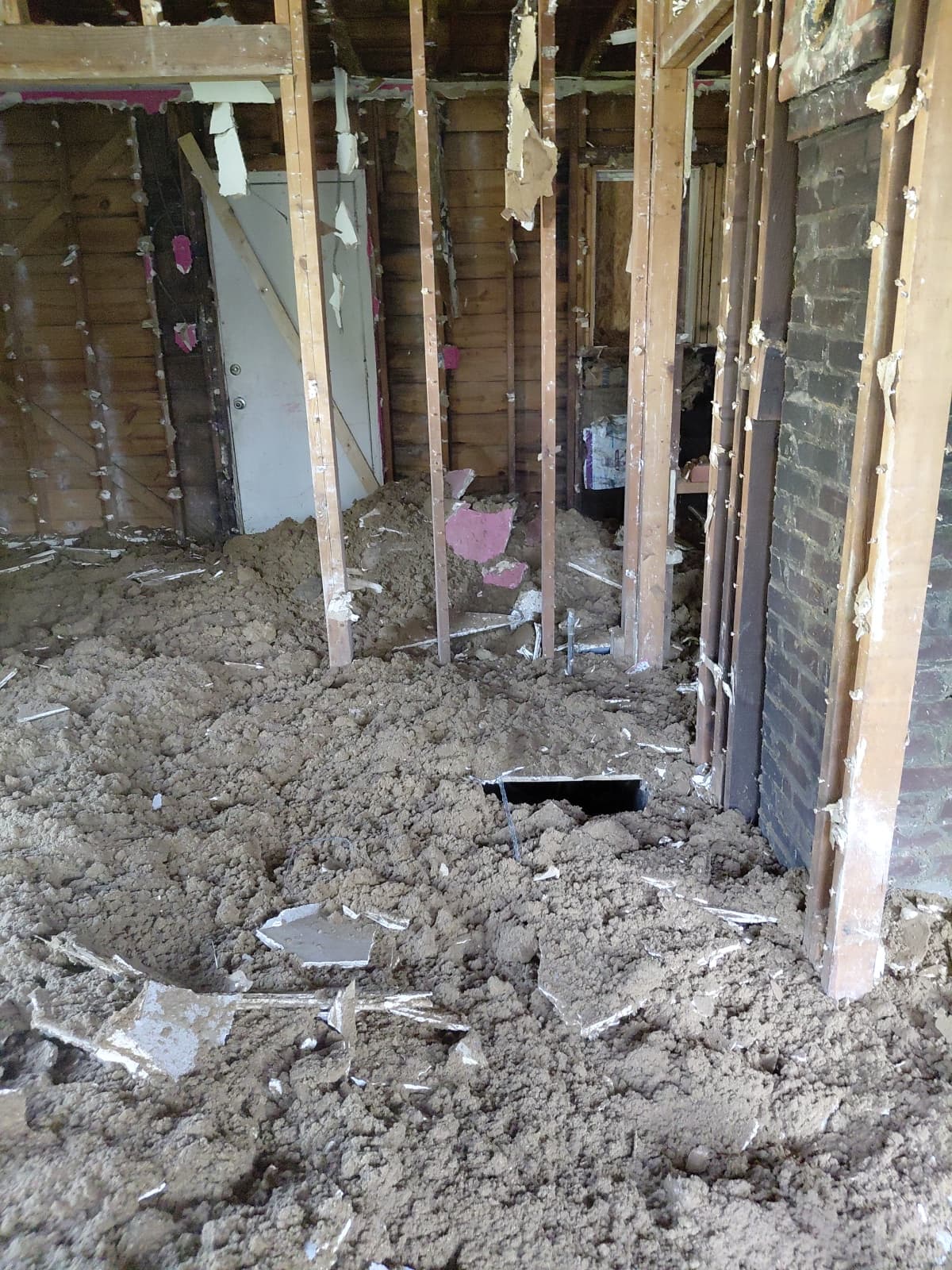 Interior demolition underway — walls stripped to the studs and debris cleared out to the dump