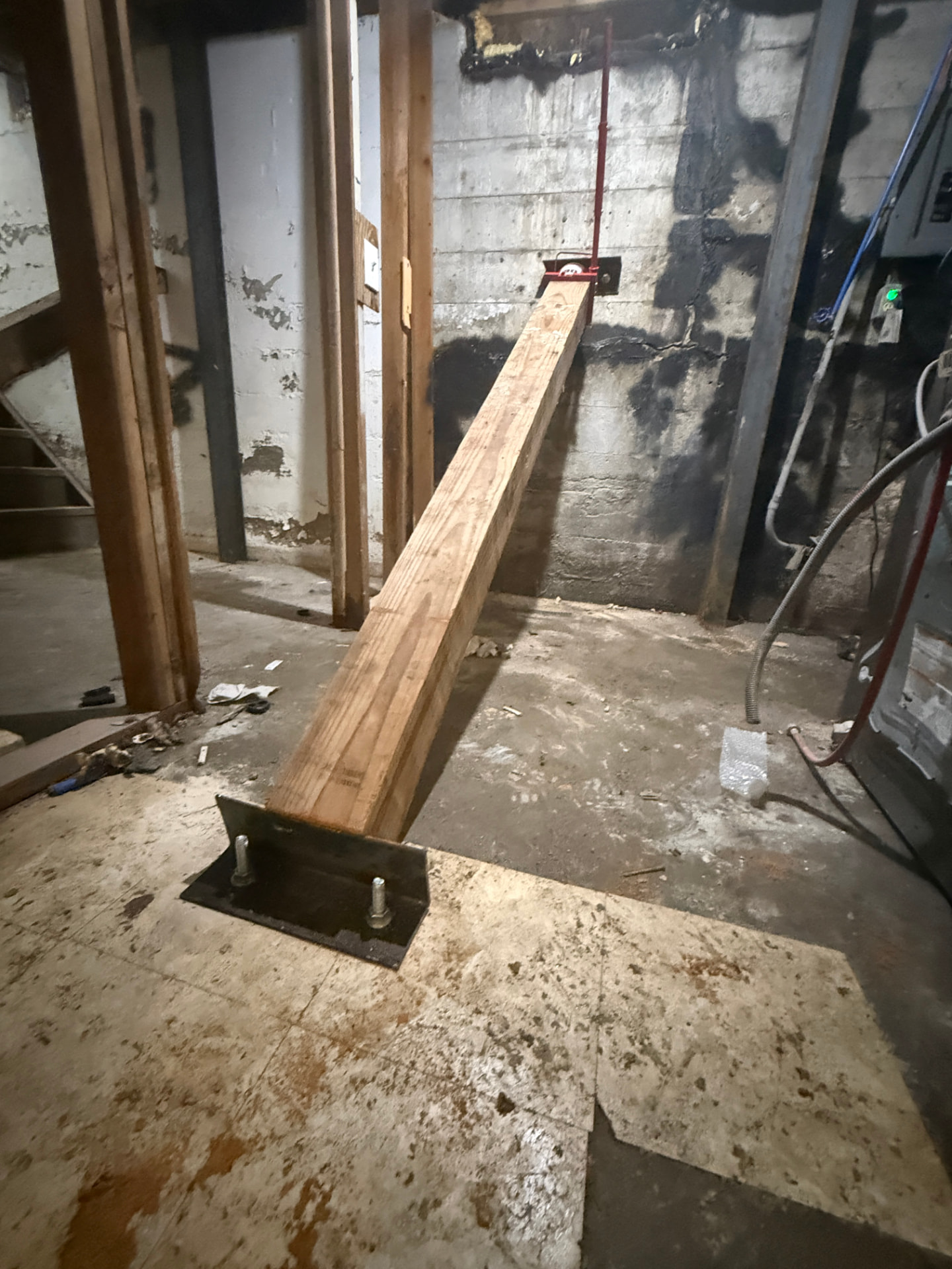 New treated post set on anchored base plate in basement