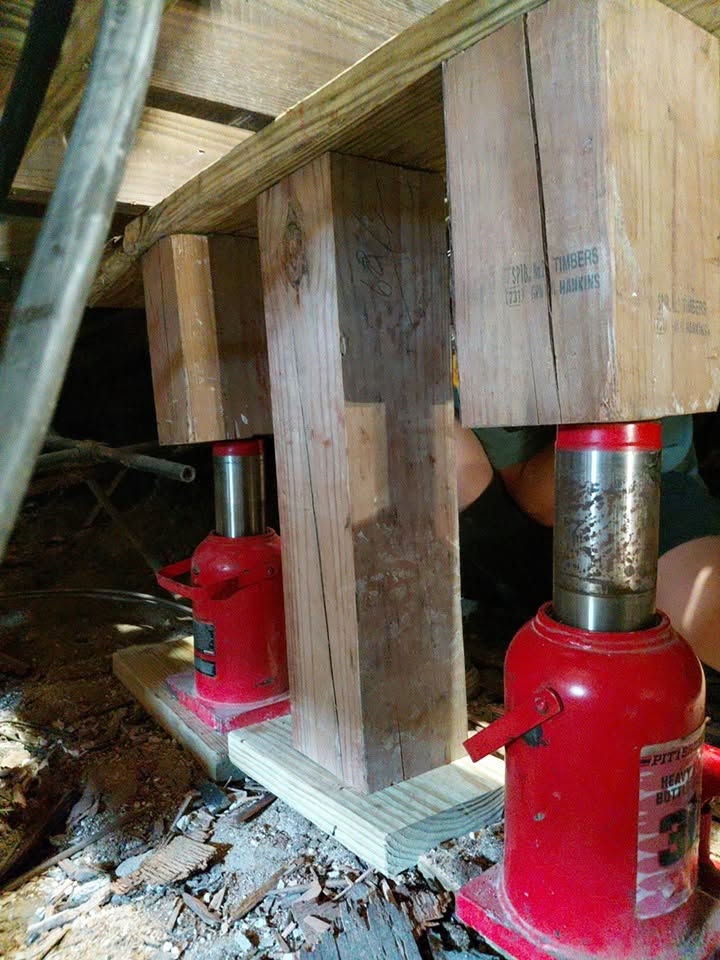 Hydraulic jacks and cribbing supporting main beam