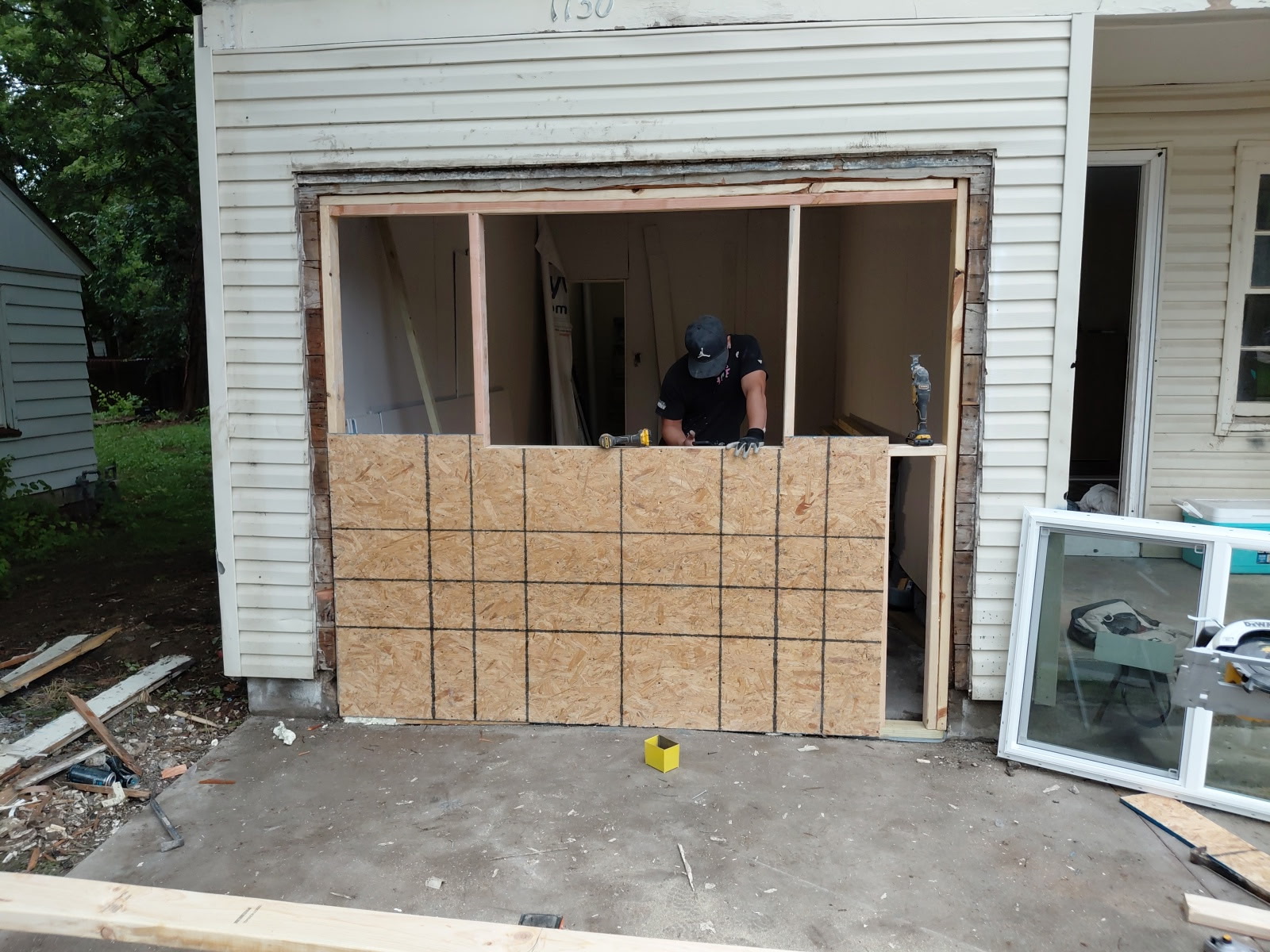 Old garage opening framed and sheathed before new siding, original worn siding still in place